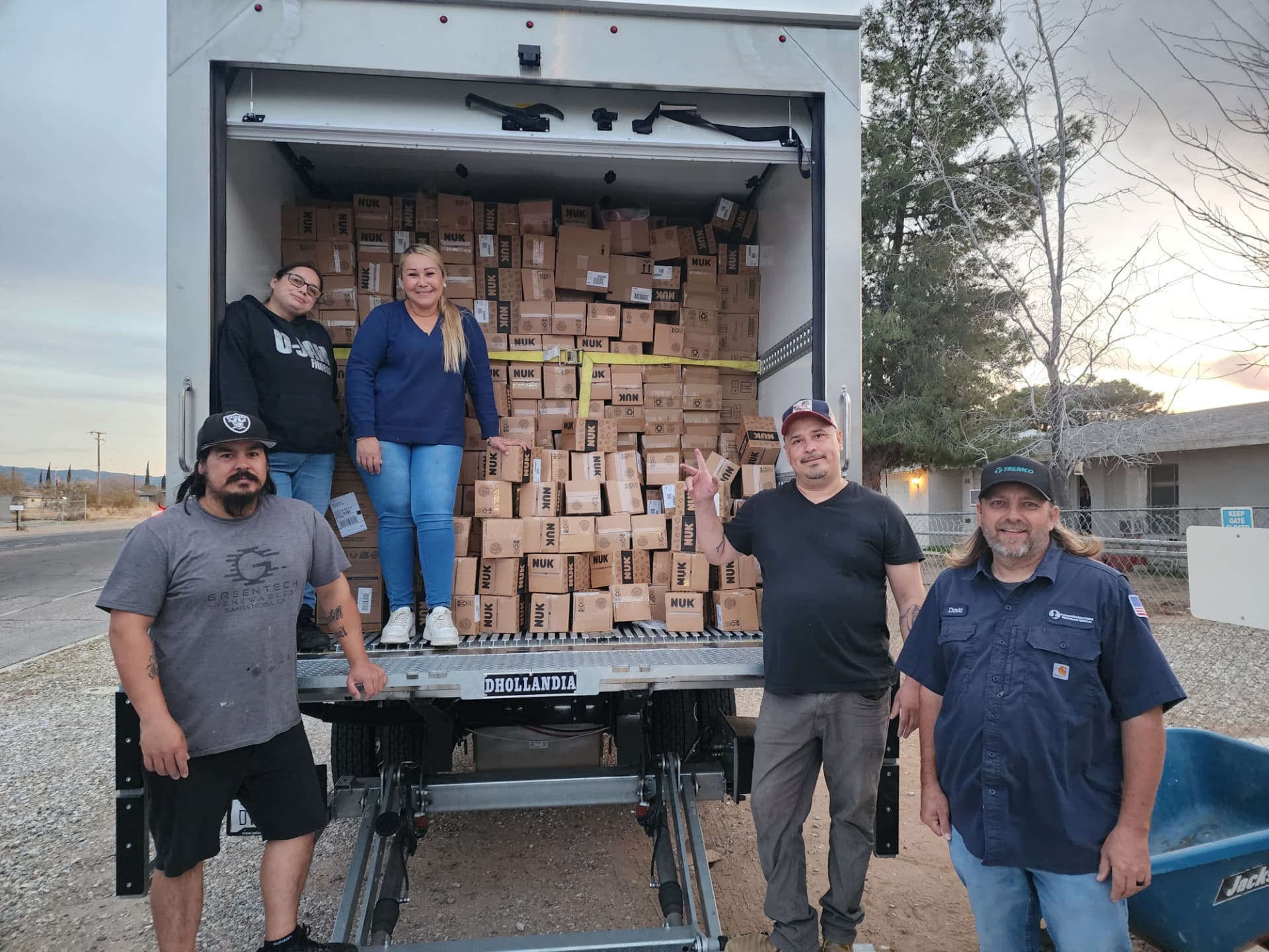 Five New Leaf Ministries volunteers smiling in front of a delivery truck loaded high with boxes of food.